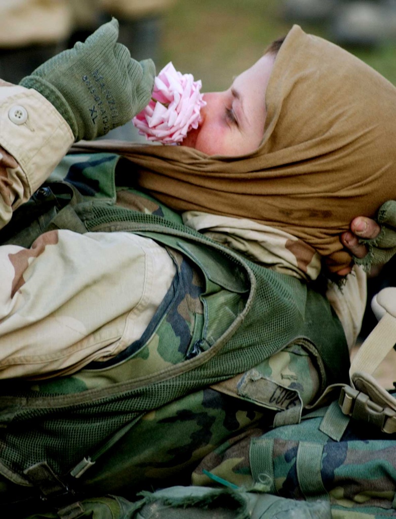 A Marine sniffs a pink rose