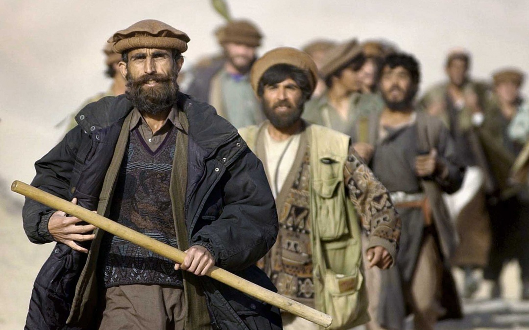 Mujaheddin soldiers armed with sticks and RPGs march toward battle