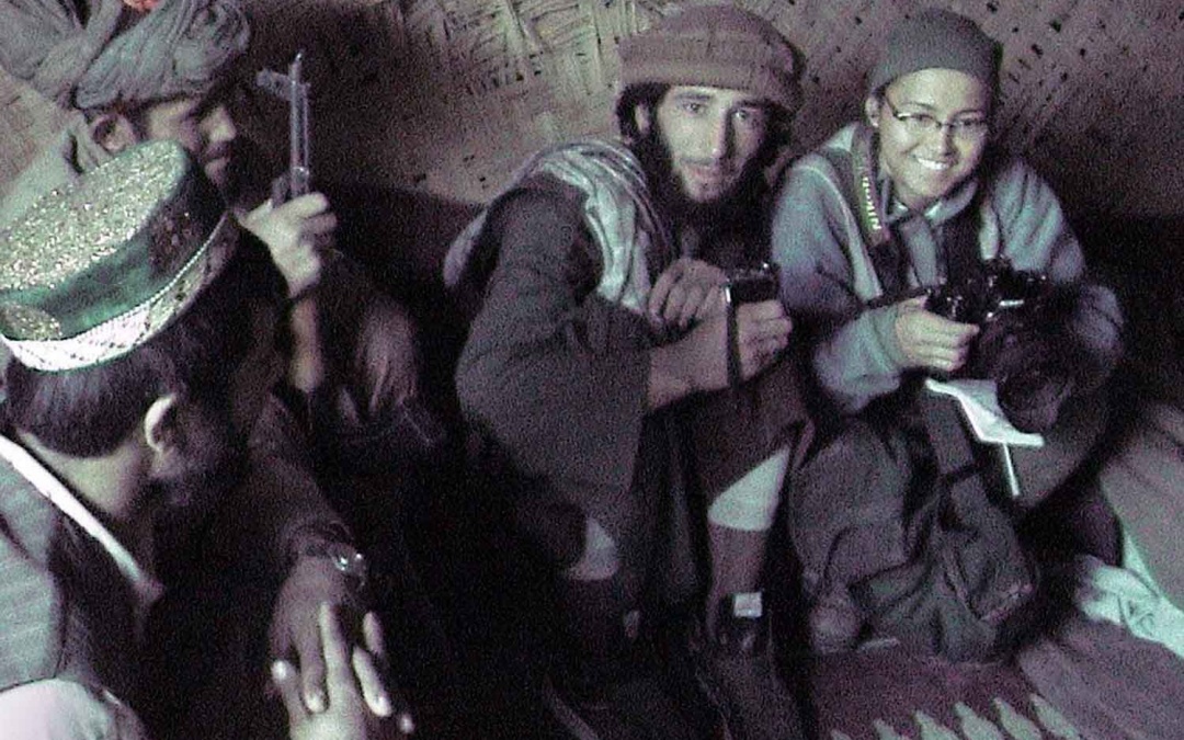 Female photographer surrounded by soldiers in Afghan bunker at the front lines