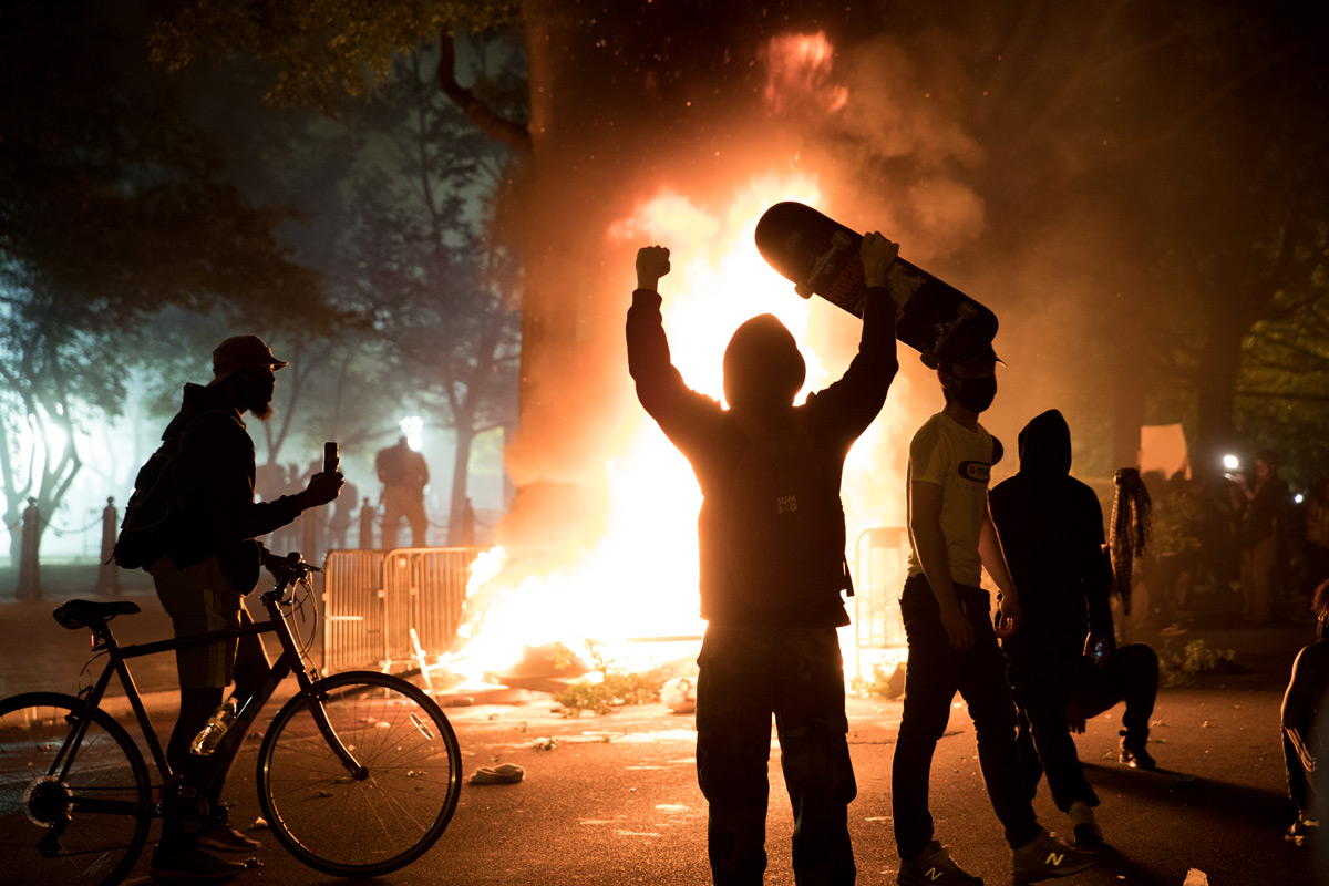 Protesters dance and cheer after setting a large fire near the White House in Washington, D.C., on Sunday, May 31, 2020. The death of George Floyd in Minneapolis last week has ignited nationwide protests. Floyd, a black man, died when a white police officer held his knee on the man's neck during an arrest. Protesters set cars, shops and the historic St. John's Church on fire and law enforcement shot tear gas, fireworks and used pepper spray against the crowds.