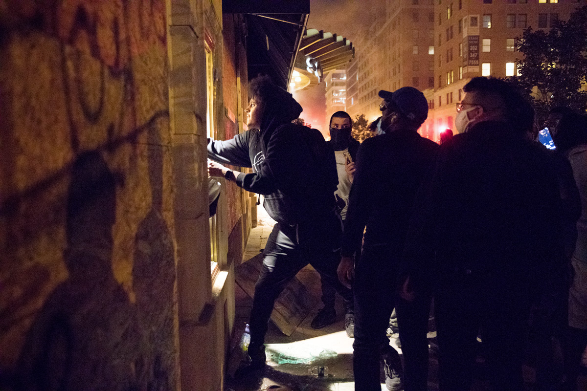 Protesters break a window and set fire to businesses near the White House in Washington, D.C., on Sunday, May 31, 2020, in response to the death of George Floyd in Minneapolis last week. Floyd, a black man, died when a white police officer held his knee on the man's neck during an arrest. Protesters set cars, shops and the historic St. John's Church on fire and law enforcement shot tear gas, fireworks and used pepper spray against the crowds.
