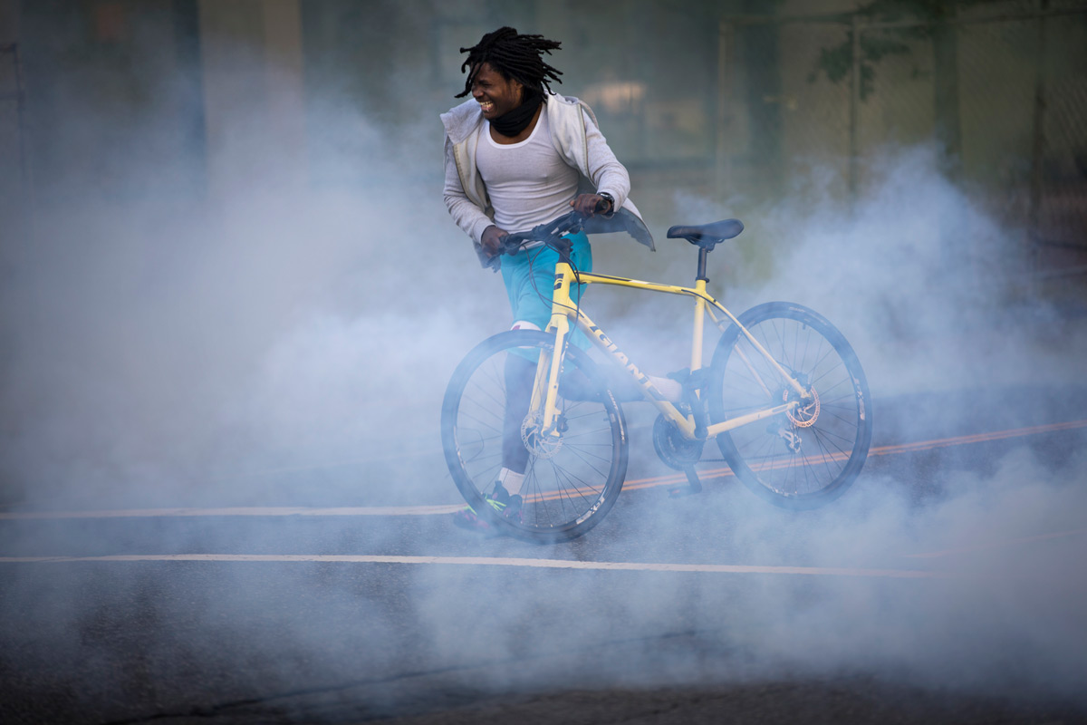 A man tries to outrun the chemical gas fired at demonstrators protesting the death of George Floyd near the White House in Washington, D.C., on Monday, June 1, 2020. Floyd, a black man, died when a white police officer held his knee on the man's neck during an arrest in Minneapolis last week. The military police, National Guard and Washington police aggressively shoved demonstrators and fired stun grenades, sting balls and chemical gas to drive them away from the White House where President Trump then walked to St. John's Church for a photo op.