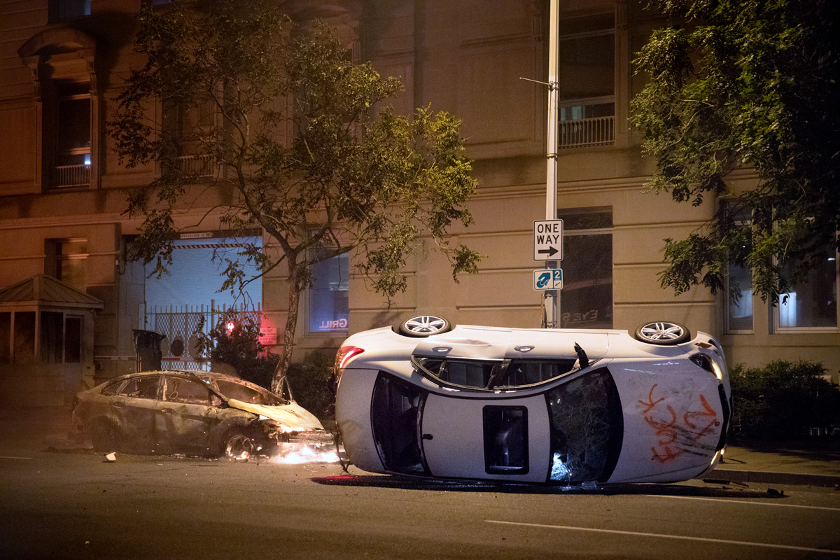 Two cars are damaged and torched by protesters after the death of George Floyd ignited nationwide protests including near the White House for a third night, in Washington, D.C., on Sunday, May 31, 2020. Floyd, a black man, died when a white police officer held his knee on the man's neck during an arrest in Minneapolis last week. Protesters set cars, shops and the historic St. John's Church on fire and law enforcement shot tear gas, fireworks and used pepper spray against the crowds.