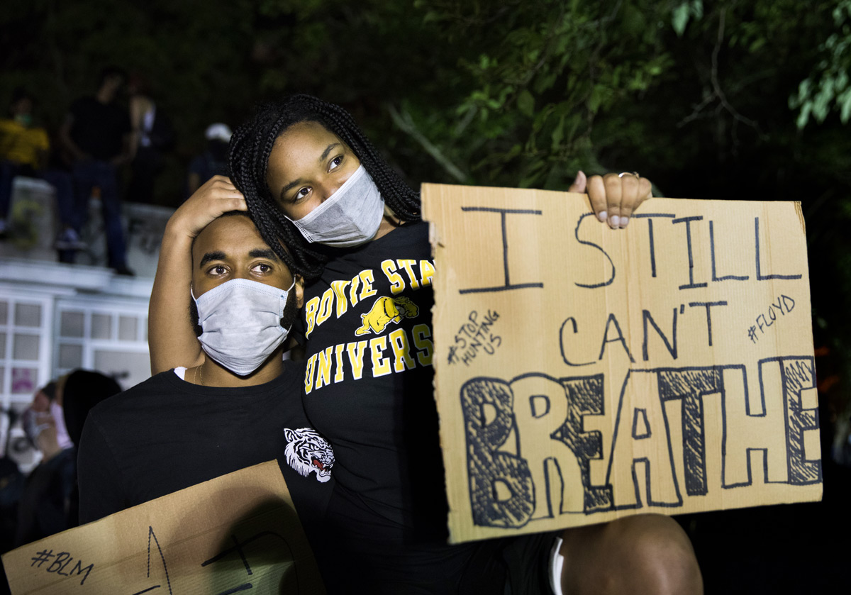 Natay Johnson, right, hugs Tay Smith, both of Washington, as they protest the death of George Floyd in front of the White House with some 10,000 other protesters in Washington, D.C., on Sunday, May 31, 2020. Floyd, a black man, died when a white police officer held his knee on the man's neck during an arrest in Minneapolis. Protesters set cars, shops and the historic St. John's Church on fire and law enforcement shot tear gas, fireworks and used pepper spray against the crowds.