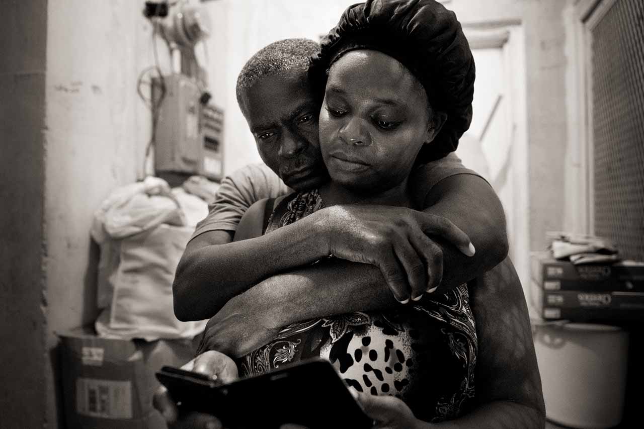 A month after Hurricane Dorian devastated the Bahamas, evacuees Sherrine Petit Homme LaFrance gets a quiet hug from husband Ferrier Petit Homme in Nassau, Bahamas, on Oct. 5, 2019. Petit Homme LaFrance and her family are staying with China Laguerre's family who took in 10 evacuees after the storm--housing, feeding and assisting them with their daily needs. Petit Homme LaFrance was staying at the Breezes Hotel, which was giving shelter to displaced residents, but was kicked out when her 14-year-old son was seen speaking to hotel guests.