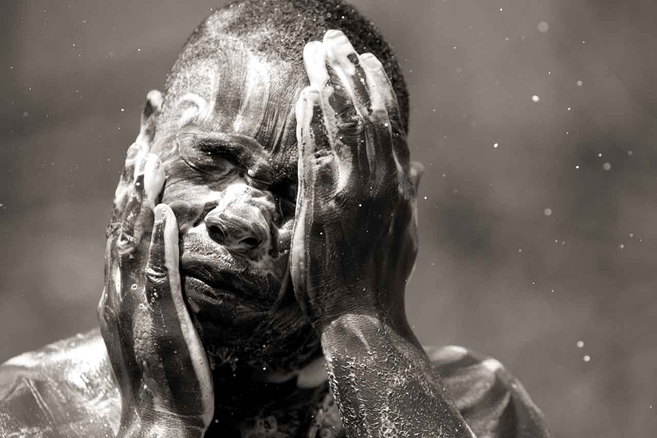 Haitian Leopaul Forestal of Marsh Harbour washes up after the nongovernmental organization World Hope set up a clean water filtration system at the Abaco Primary School on the island of Abaco in the Bahamas on Sept. 8, 2019. Some 50 Haitian evacuees from Hurricane Dorian still remained in the shelter a week after the storm, distrustful of the Bahamian government's promises to care for them, while many others were taking boats and planes to seek shelter in Nassau, the Bahamian capital.