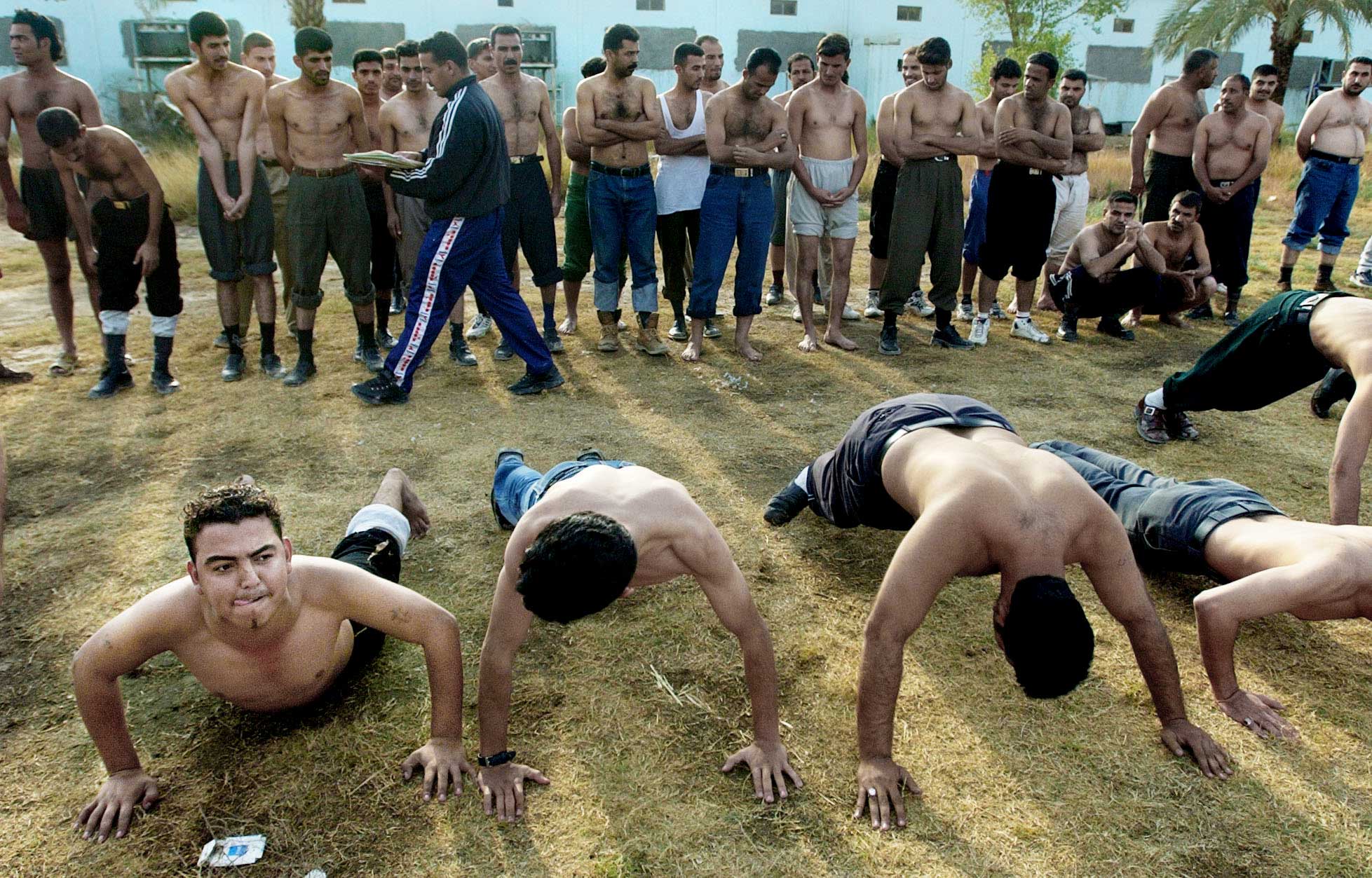 At the Baghdad Police Academy, former Iraqi police officers and new cadets endure physical fitness training as part of the U.S. forces' efforts to return control and law enforcement to the Iraqis.