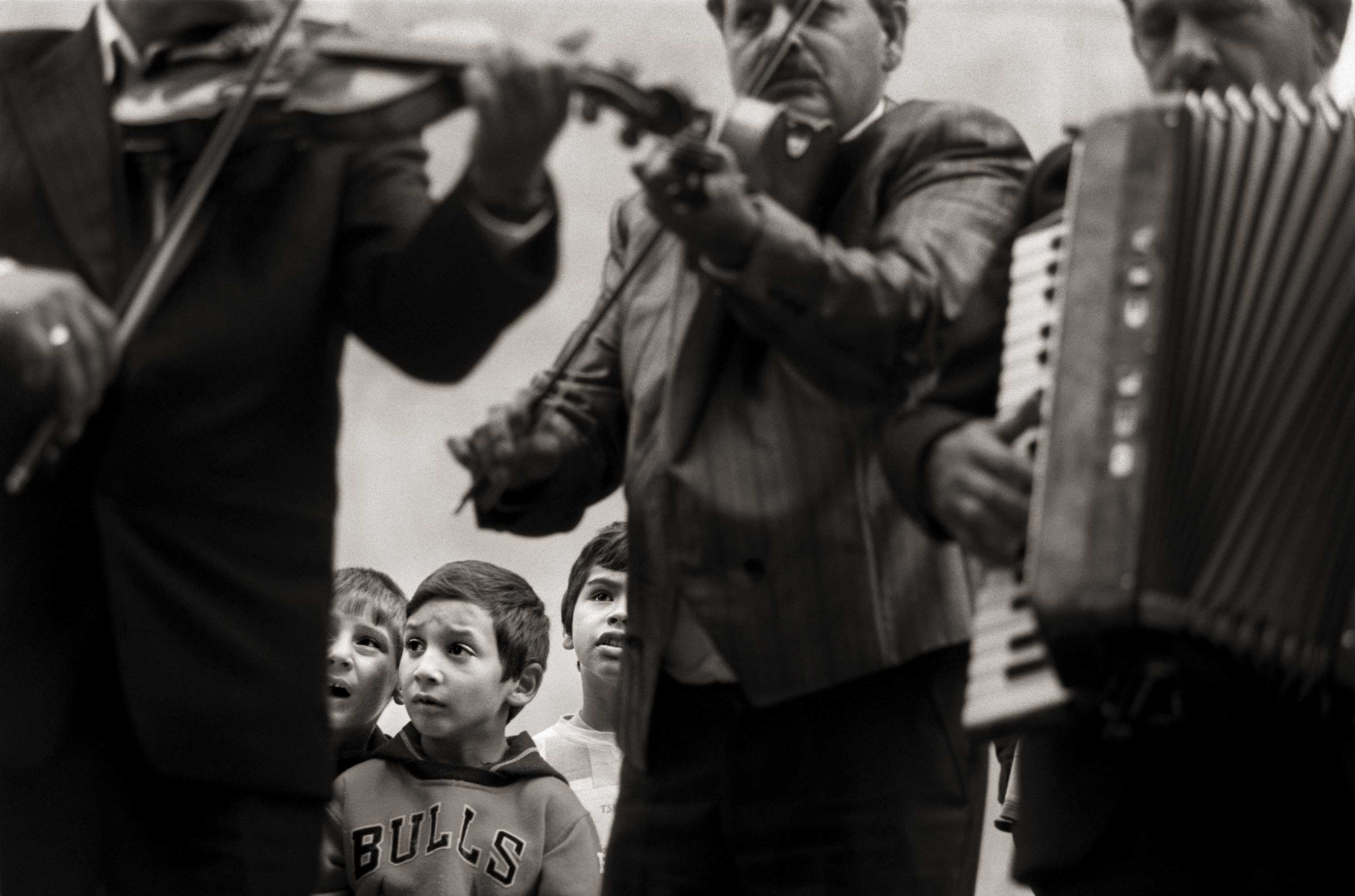 Roma children listen to musicians playing a lilting tune for the funeral of a 21-year-old man in Chanov, the Czech Republic.