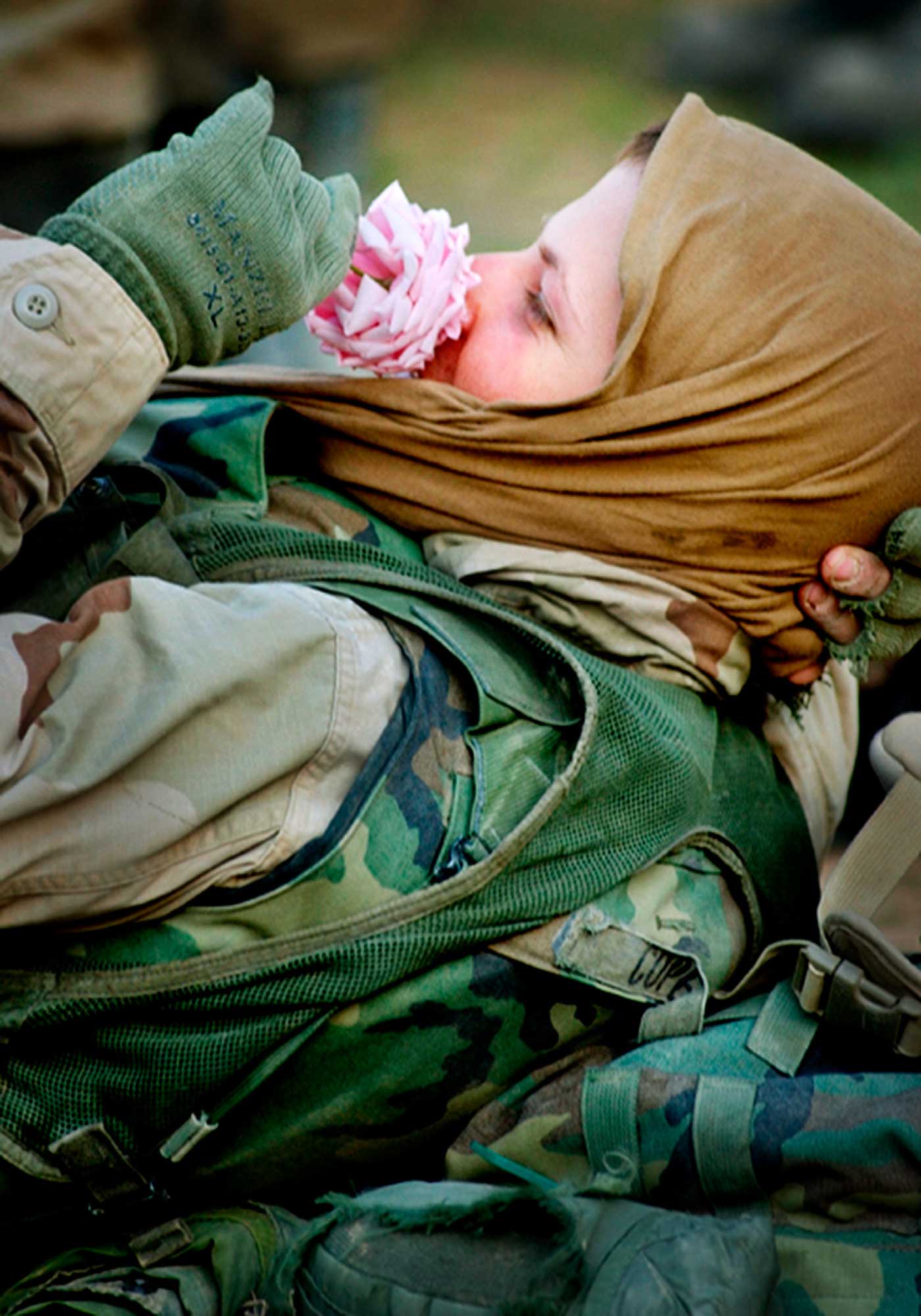 U.S. Marine Corporal Richard Cope, 23, of Michigan, enjoys the scent of a rose plucked from the gardens of Baghdad College where the Fox Company, Second Tank Battalion, Fifth Marine Regiment, are camped in the north of Baghdad, Iraq.