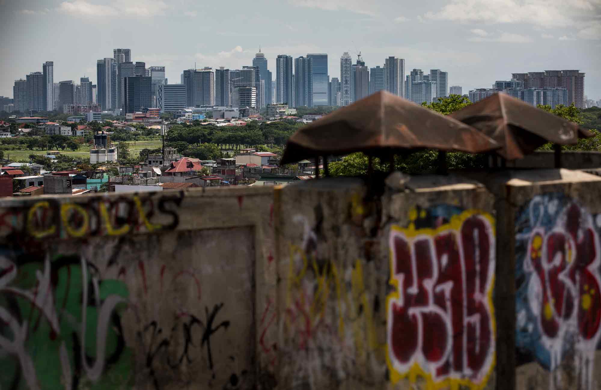 Built in 1963, the Tenement in Taguig overlooks Makati's wealthy high rises in Metro Manila, Philippines. In 2014, the National Housing Authority condemned it and posted eviction notices, with a promise of relocation in the neighboring city of Cavite. But a contradictory study by the Department of Works and Highways said the building could be retrofitted, so residents have been fighting to keep the building ever since.