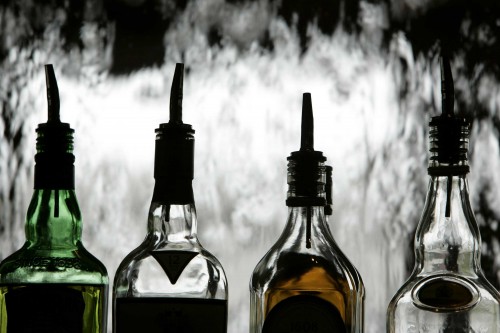 The Woodlands restaurant in Dallas, Texas, serves seafood, steaks and an array of creative dishes. Four bottles of alcohol are shown in relief with a dramatic background.